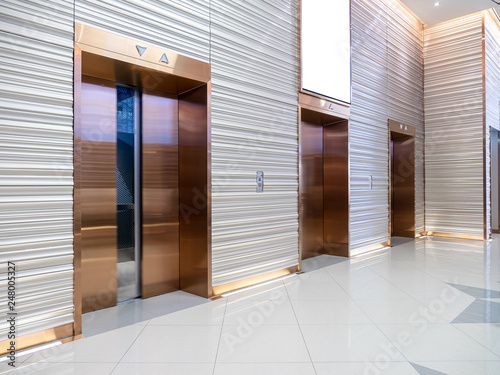 Modern steel elevator cabins in a business lobby or Hotel, Store, interior, office,perspective wide angle. Three elevators in hotel lobby