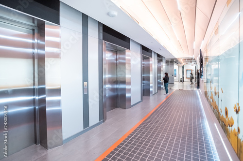 Modern steel elevator cabins in a business lobby or Hotel, Store, interior, office,perspective wide angle. Three elevators in hotel lobby.