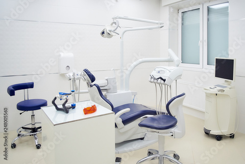 New interior of a dental office with white and blue furniture  dental chair  intra oral scanner. Dentist   s office.