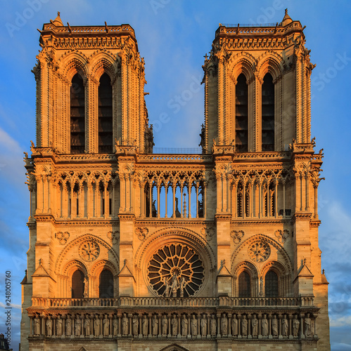 Details of the southern facade of Notre Dame de Paris Cathedral facade with the oldest rose window and ornate tracery in the warm light of sunset