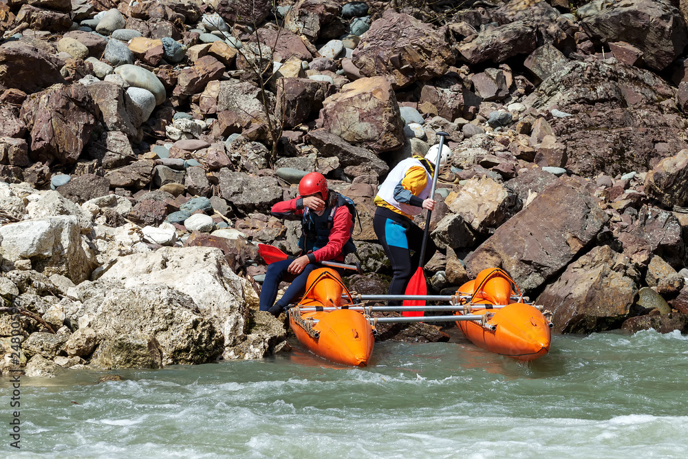 Brave people travel by raffting on a mountain river