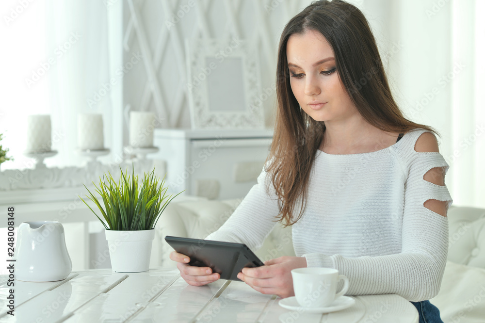 Portrait of young woman using digital tablet at home Portrait of young woman using digital tablet at home