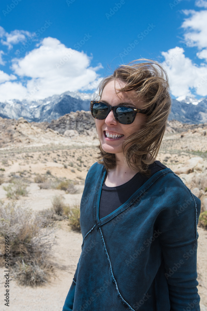 Naklejka premium Portrait of Adult female wearing sunglasses on a windy summer day in the Alabama Hills in Lone Pine California, in the Eastern Sierra Nevada Mountains