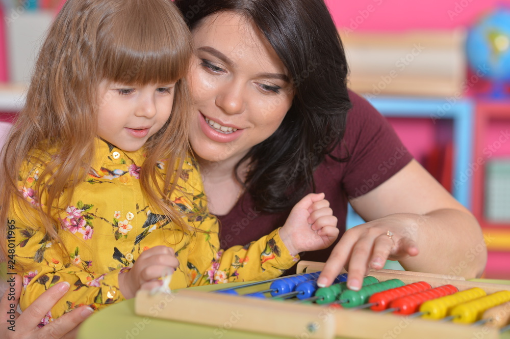 Portrait of mother teaching daughter to use abacus Portrait of mother teaching daughter to use abacus