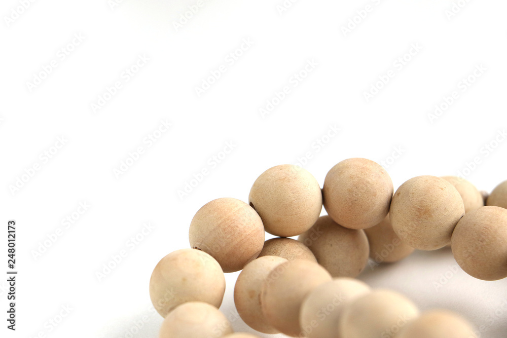 string of unvarnished wooden beads on a white surface, shot with a short depth of field string of unvarnished wooden beads on a white surface, shot with a short depth of field