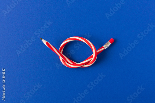 Flexible pencil . Isolated on blue background. Bending pencil.