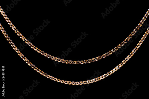 Golden chain weaving non, on a black background. Isolate, macro, soft focus.