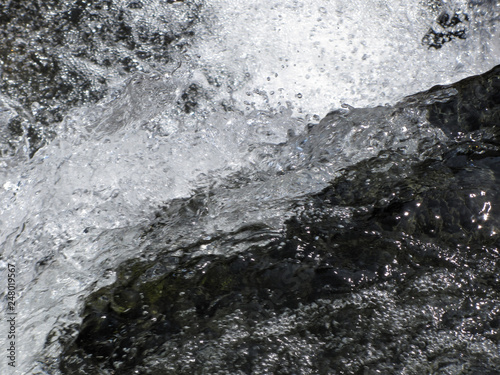 Water flowing and splashing over rocks background