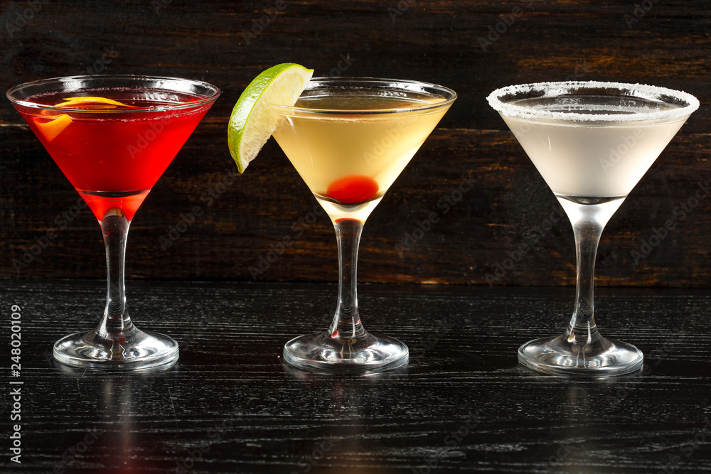 Alcoholic cocktail row on wood backgroundks, colorful party drinks. Set of classic cocktails.