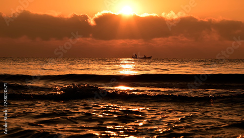 sunset on the sea with traditional fisher man boat from Romania at the black sea  