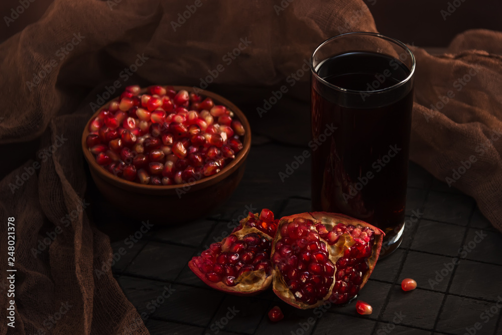 Pomegranate juice in a glass and pomegranate fruit in a cup