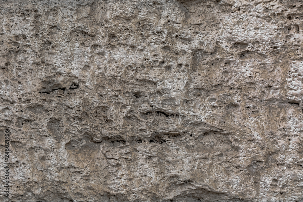 Textured uneven stone surface. Yellow limestone. Background image. Construction material. Textured uneven stone surface. Yellow limestone. Background image. Construction material.