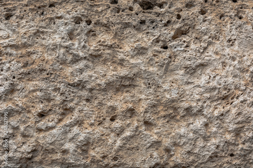 Textured uneven stone surface. Yellow limestone. Background image. Construction material.