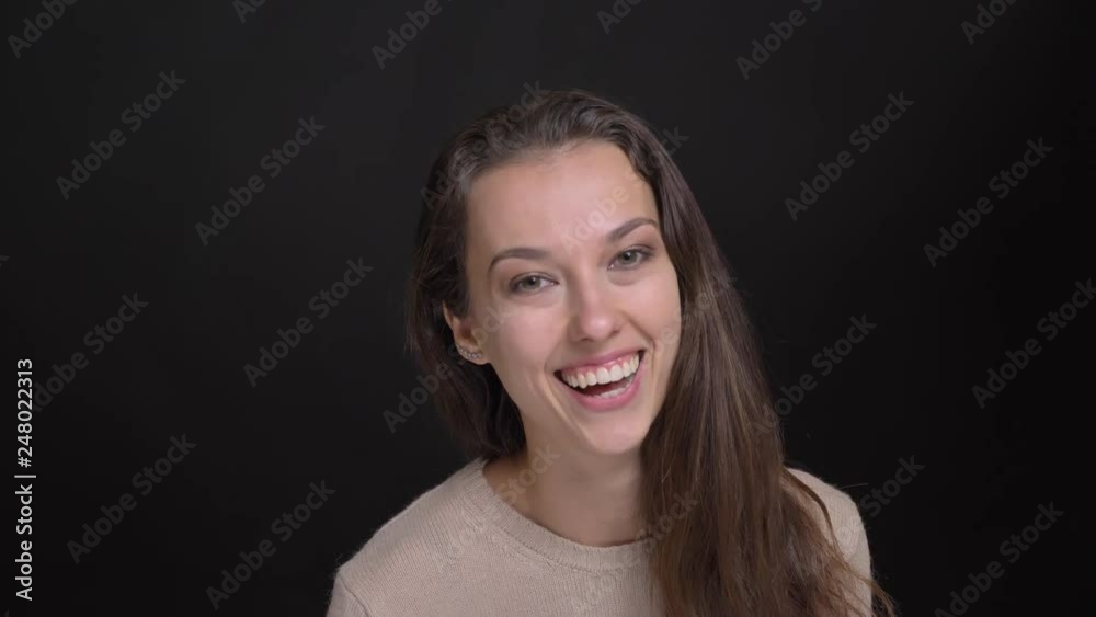 Close-up portrait of brunette long-haired caucasian girl joyfully making funny faces into camera on black background. Close-up portrait of brunette long-haired caucasian girl joyfully making funny faces into camera on black background.