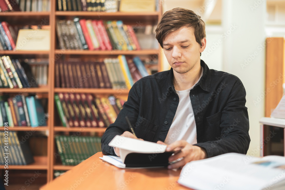 student take notes in his notebook at school or university b student take notes in his notebook at school or university b