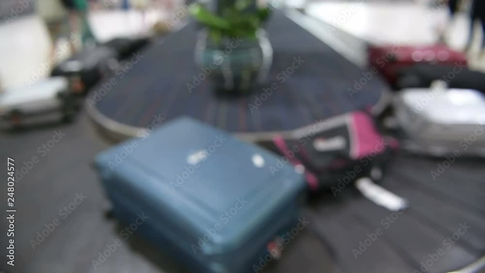 Suitcase or baggage on luggage conveyor belt in an arrivals lounge of airport terminal Suitcase or baggage on luggage conveyor belt in an arrivals lounge of airport terminal