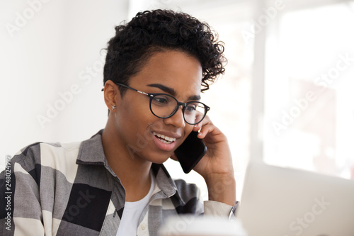 Fototapeta Happy black female saleswoman talking on the phone making call