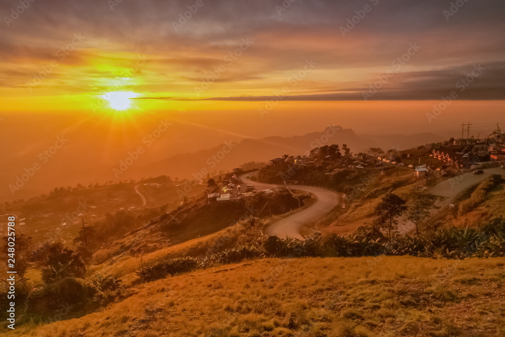 Mountain view morning of curve road around with the hill and colorful of yellow sun light in the sky background, sunrise at Phu Thap Boek, Phetchabun, Thailand.