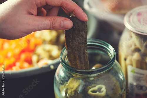 woman hand pickles on jar