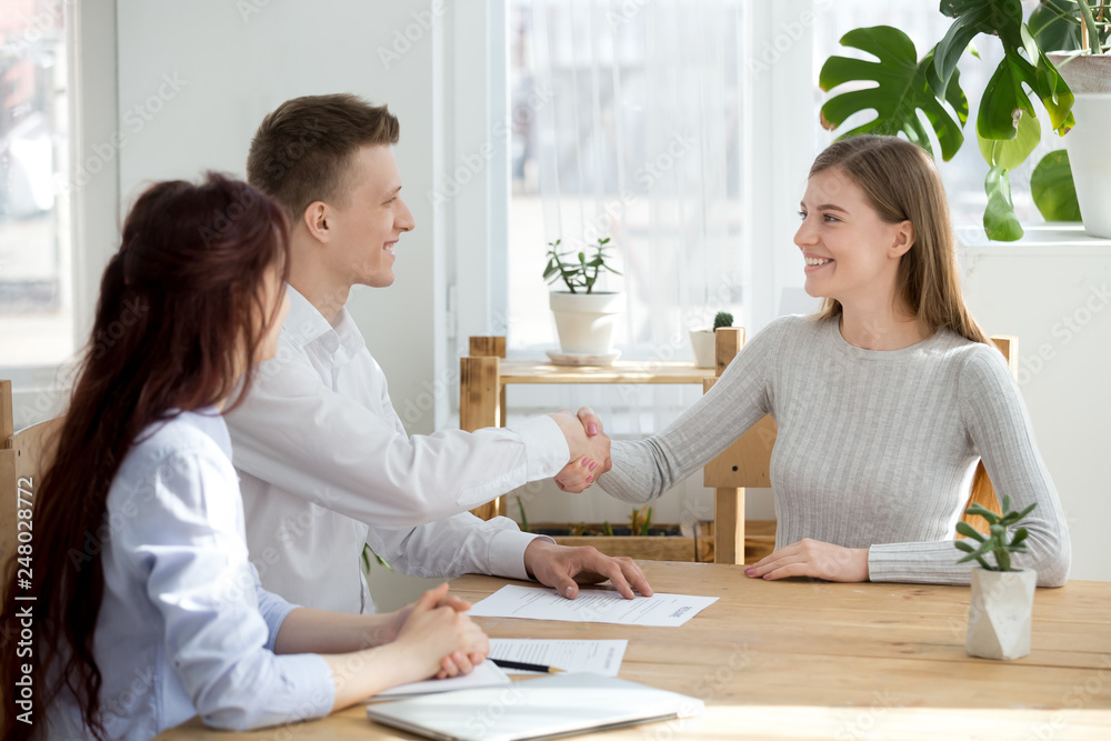 Smiling friendly hr manager handshaking applicant welcoming at job interview Smiling friendly hr manager handshaking applicant welcoming at job interview