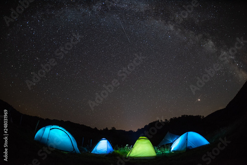 Illuminated tent under the summer clear sky full of stars , Transylvania Romania  