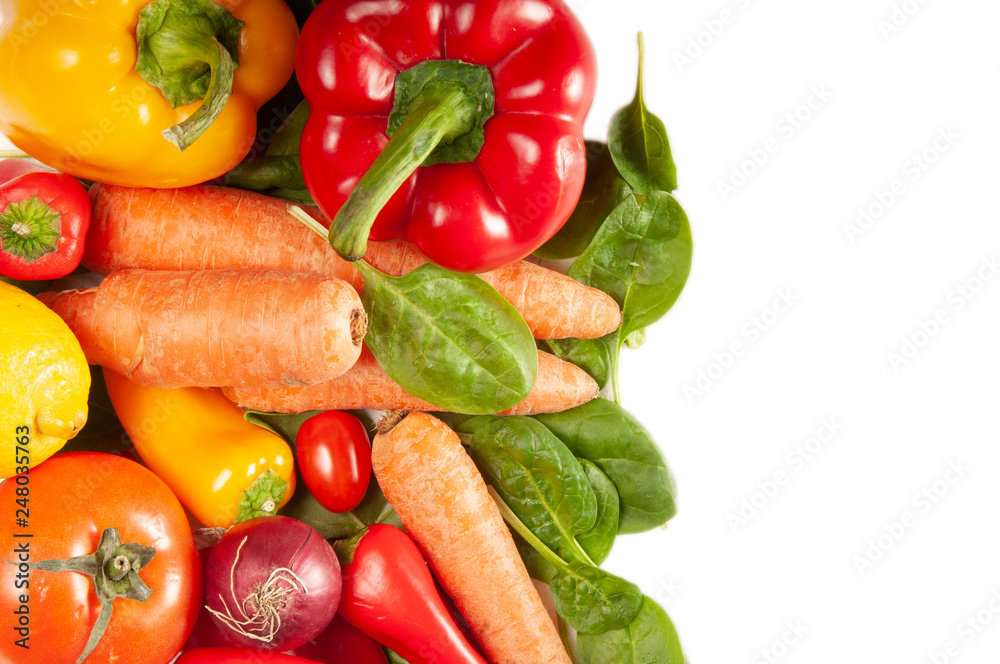 Spinach, carrots, peppers, tomatoes, onions and lemon on a white background with space for text Spinach, carrots, peppers, tomatoes, onions and lemon on a white background with space for text