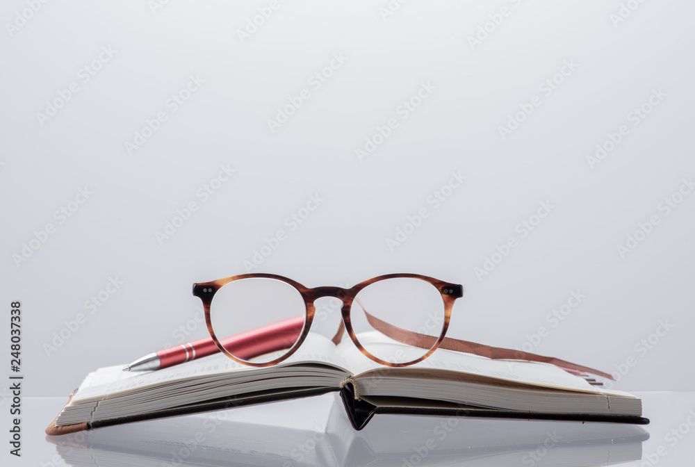 Diary planner opened book, reading glasses and pen with toned background Diary planner opened book, reading glasses and pen with toned background
