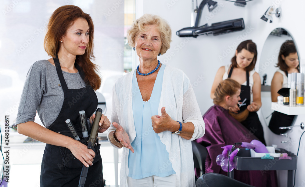 Smiling elderly woman with hairdresser