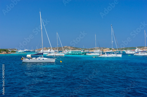 Yachts and boats anchored at beautiful beach of archipelago la Maddalena. Sardinia, Italy