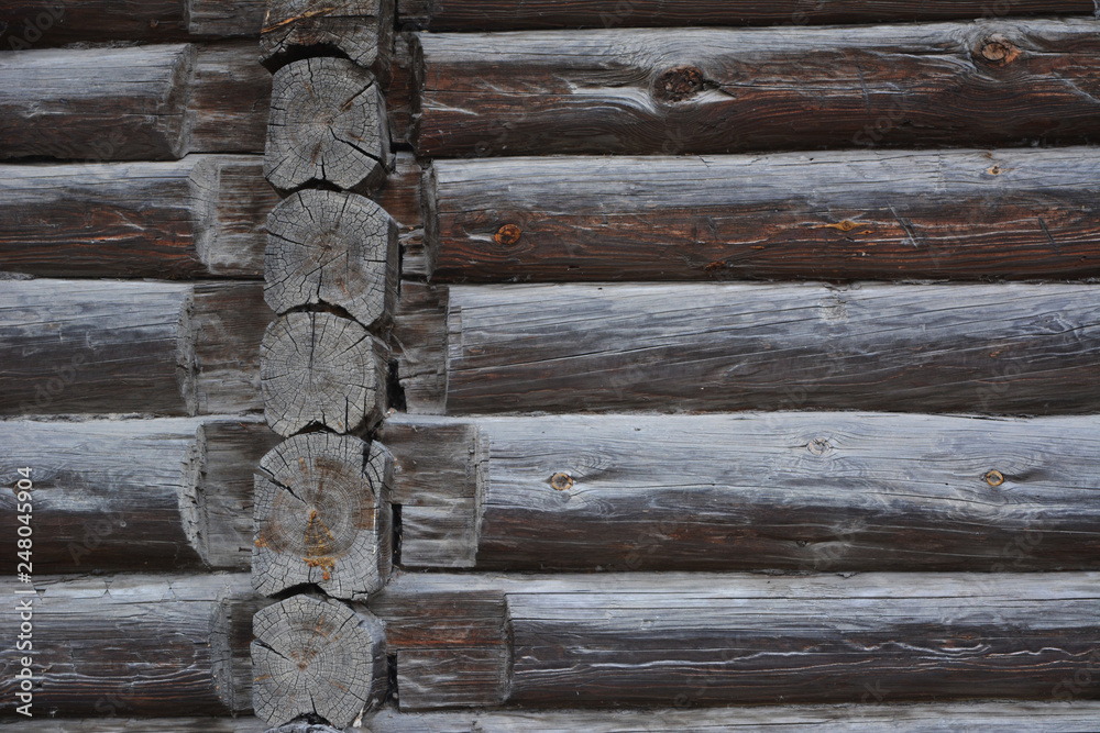 Old wooden wall of blockhouse. Facade of a log house built at the end of 19th century without nails in Russia. Old wooden wall of blockhouse. Facade of a log house built at the end of 19th century without nails in Russia.