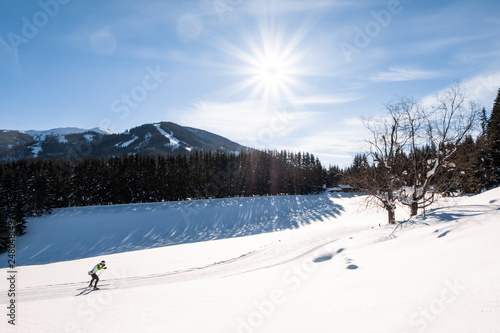 Adult man running cross-country skiing in snow-covered holiday resort Hohentauern