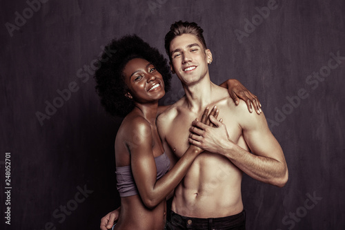 Joyful positive woman putting her hand on boyfriends chest
