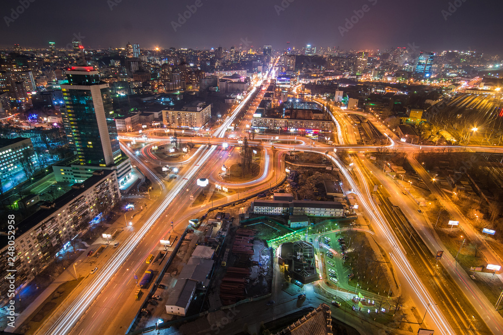 Highway in city at night with trails of car lights