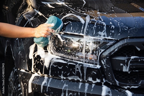 Man hands to catch the sponge and polish the car window. Concept car wash.