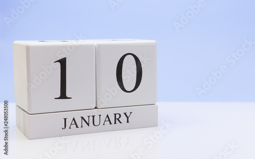 January 10st. Day 10 of month, daily calendar on white table with reflection, with light blue background. Winter time, empty space for text