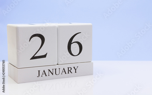 January 26st. Day 26 of month, daily calendar on white table with reflection, with light blue background. Winter time, empty space for text