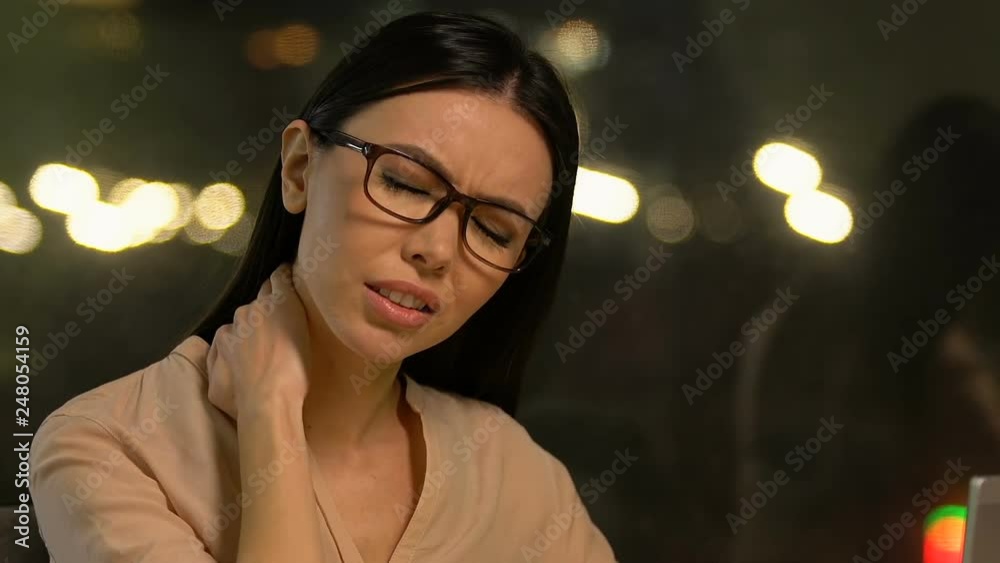 Female freelancer working on laptop and rubbing neck, suffering strong pain Female freelancer working on laptop and rubbing neck, suffering strong pain