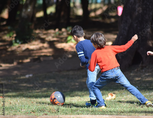boys playing football in park
