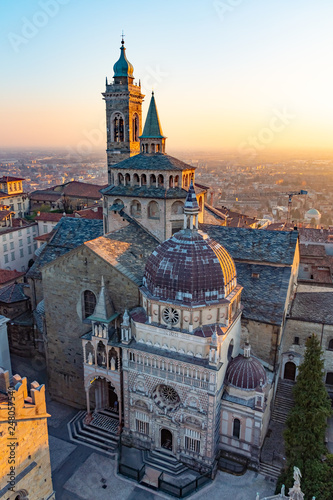 Aerial view of the Basilica of Santa Maria Maggiore and the chapel Colleoni during the sunset with Po plain in background, Citta Alta, Bergamo, Italy