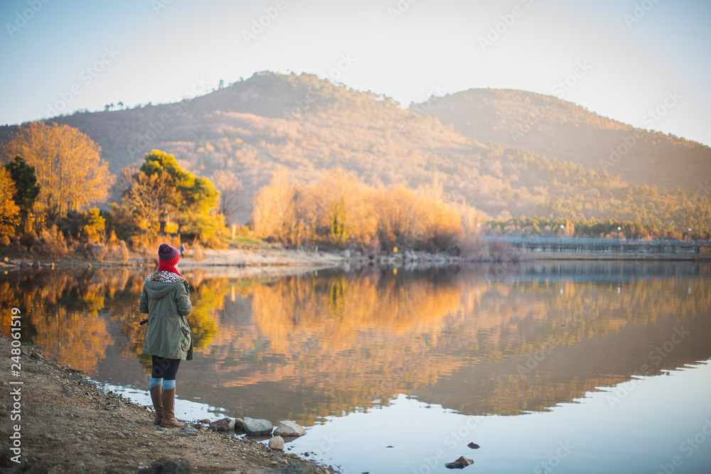 young woman looking lake landscape