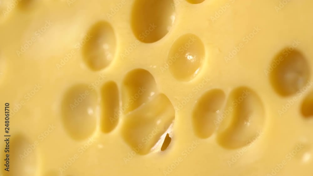 Hard cheese with holes on the cutting board Hard cheese with holes on the cutting board