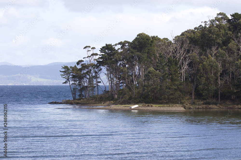 Row boat rests on shores of Daniels Bay in Tasmania