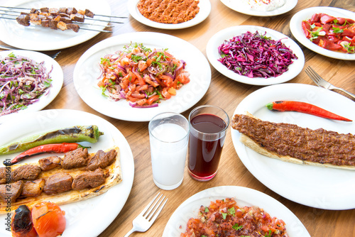 Traditional Turkish Adana Kebab or kebap meat food, raki and salgam in Turkish Restaurant with salad