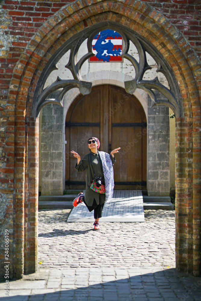 touriste posant sour une arcade Bruges