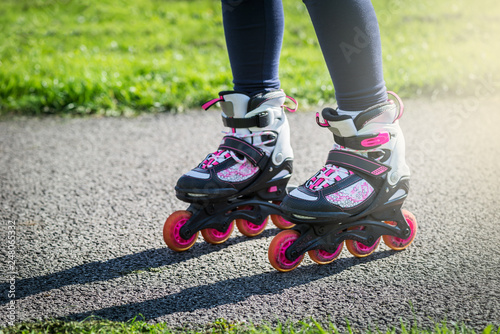 Teenage girl is skating on roller blades in the park