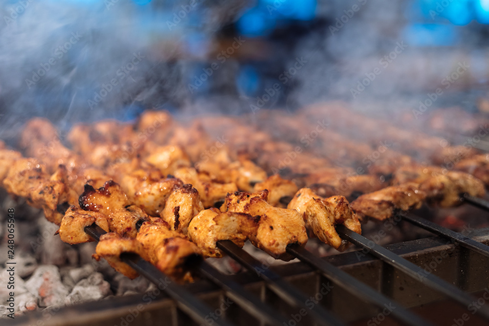 Chicken shish Kebab or kebap meat on metal skewer barbecue and embers in the Turkish restaurant. Skewering bbq Chicken Kebab..