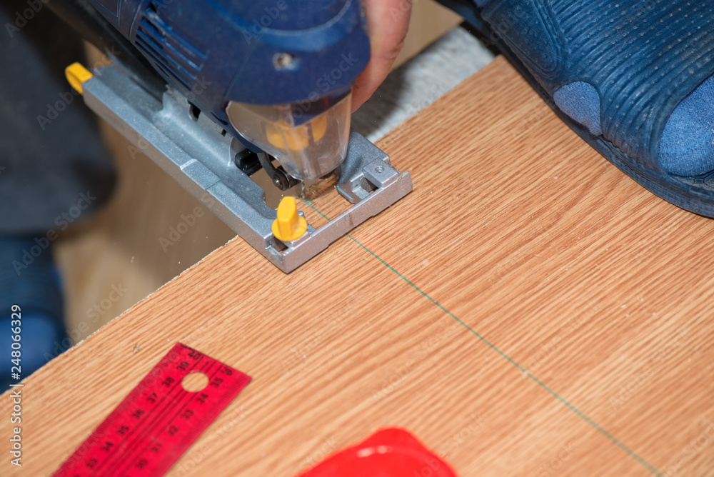 Person cutting wooden board with a machine