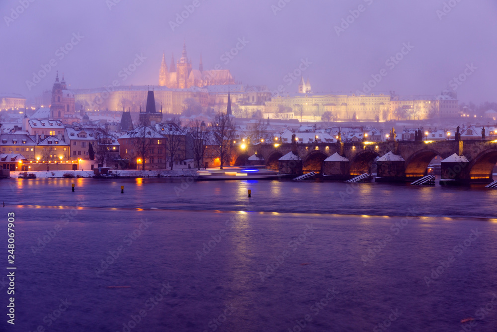 Foggy night Prague Lesser Town with gothic Castle, Bridge Tower and St. Nicholas' Cathedral in the Snowstorm, Czech republic