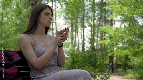 Pretty Girl Relaxing In The Park And Smoking Cigarette