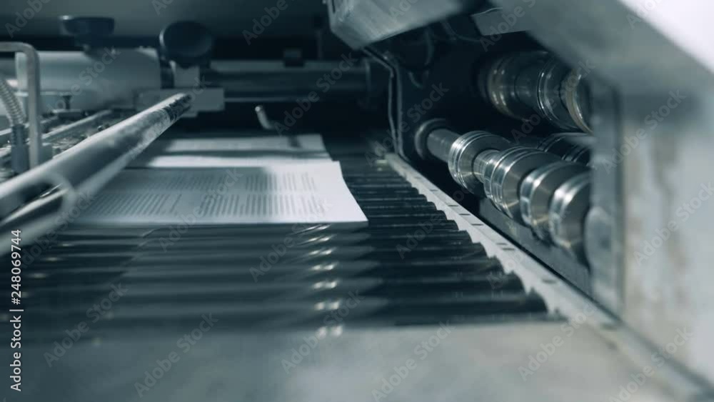 Printed sheets moving on a special conveyor, close up. Printed sheets moving on a special conveyor, close up.